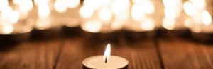 bigstock-One-candle-and-blurry-candles-88738196-1280x420